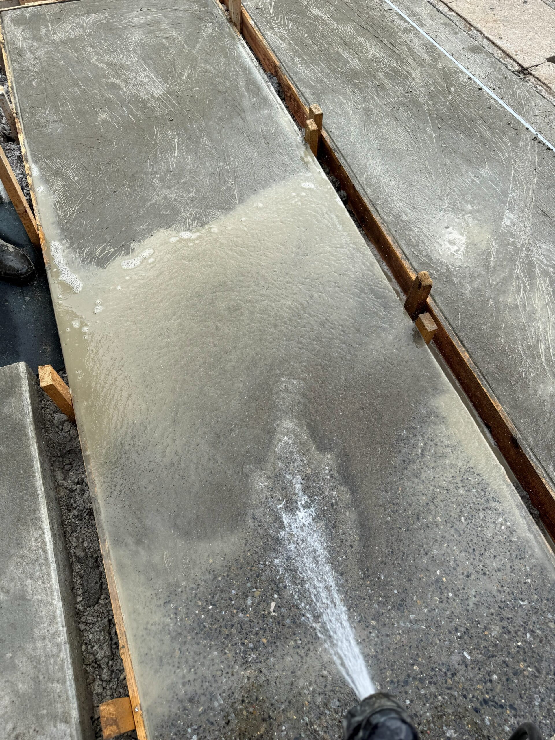 土間コンクリートを水で洗い出して砂利を出す作業